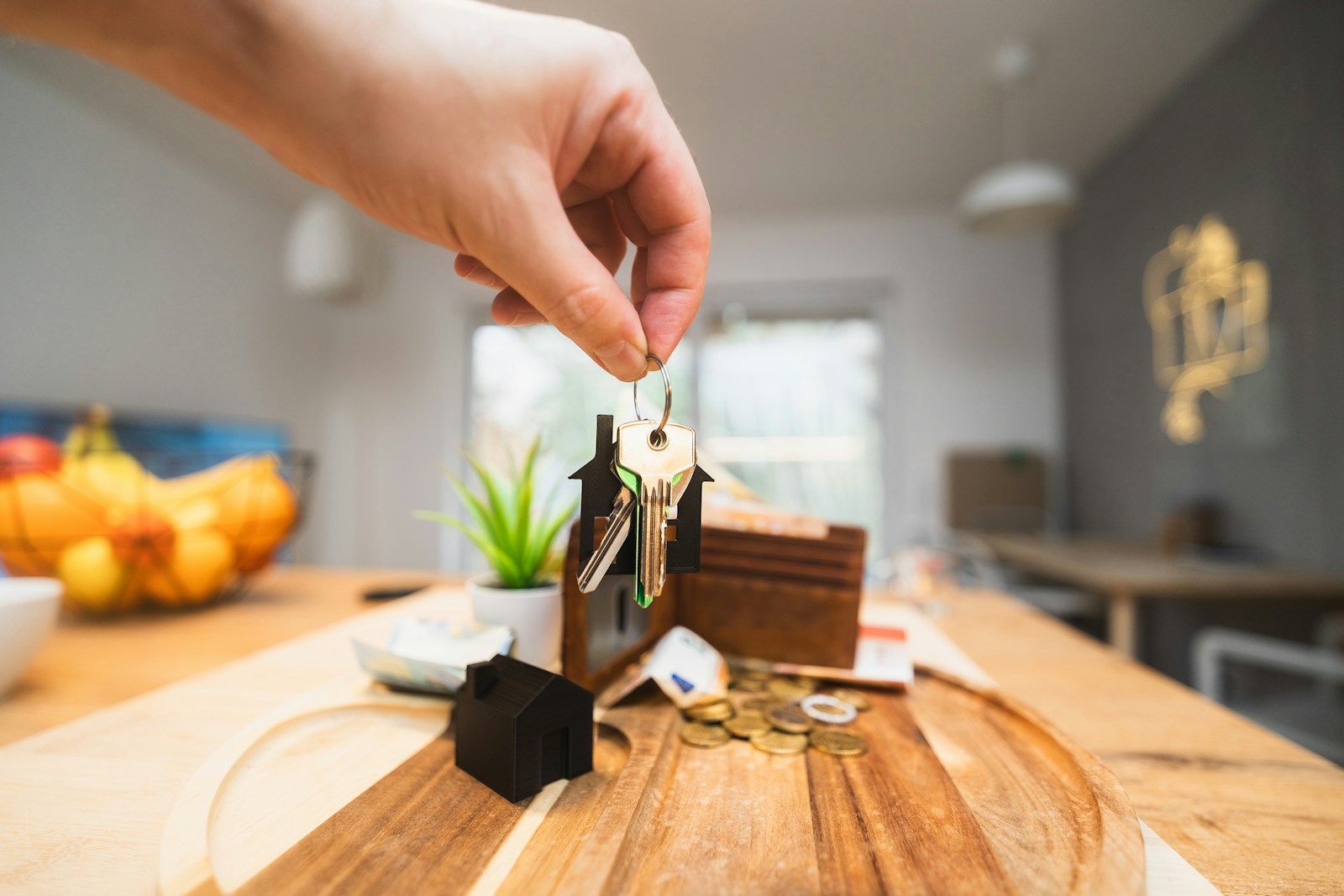 A person holding a piece of wood on top of a wooden table