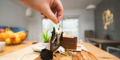 A person holding a piece of wood on top of a wooden table